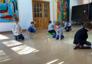 Grupa dzieci łapie kolorowe piórka